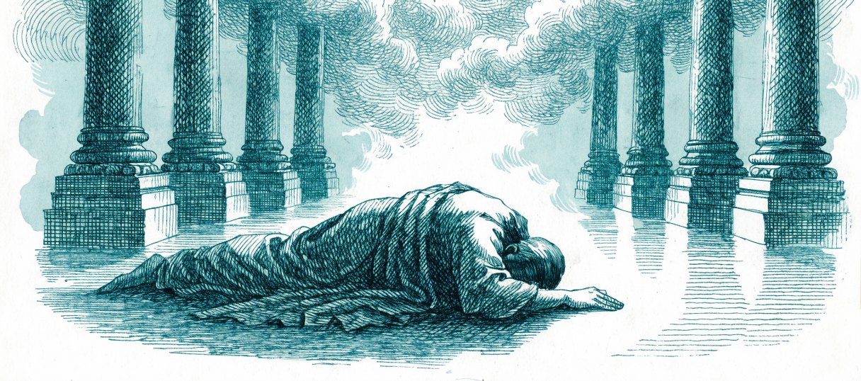 A man lying face down on the stone floor of a vast columned temple hall as smoke fills the space above him